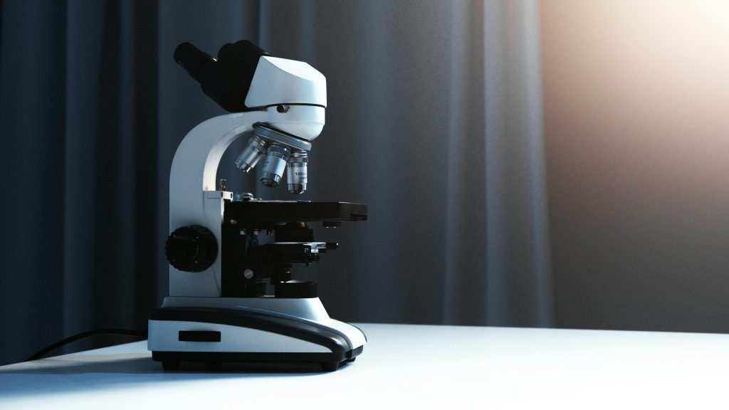 Close-up of a modern microscope in a laboratory with soft lighting.