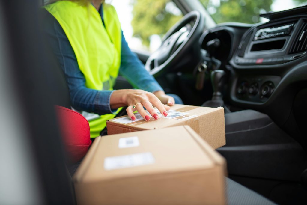Courier organizing parcels inside a vehicle, highlighting the delivery process. Perfect for logistics themes.